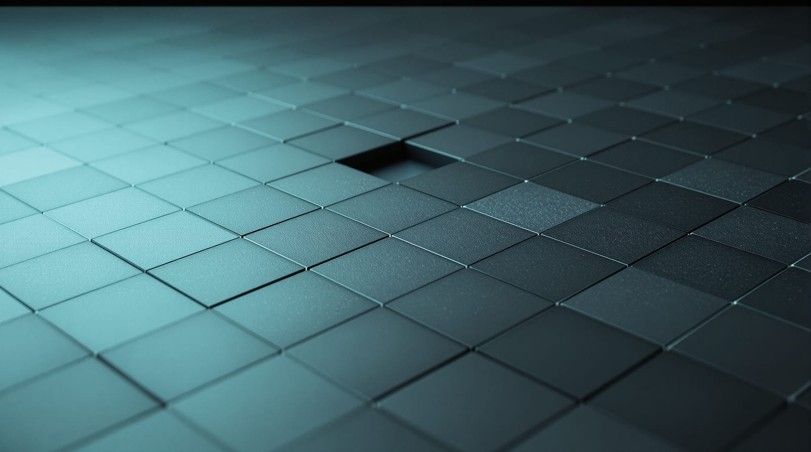 Low-angle view of a grid of matte graphite tiles with several tiles missing, lit by a diffuse cyan wash, open space at right